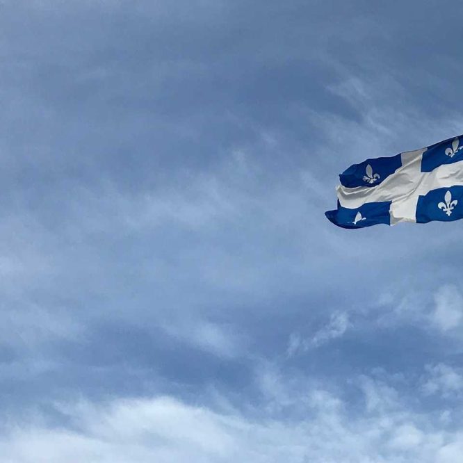 Drapeau du Québec flottant sous un ciel bleu