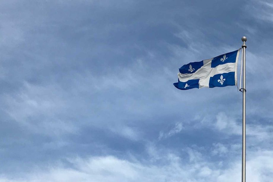 Drapeau du Québec flottant sous un ciel bleu